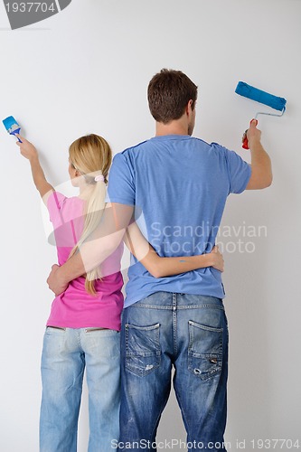 Image of happy couple paint wall at new home