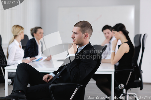 Image of handsome young business man with colleagues in background