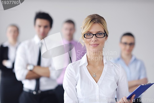 Image of business woman standing with her staff in background