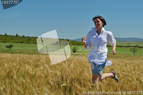 Image of young woman in wheat field at summer