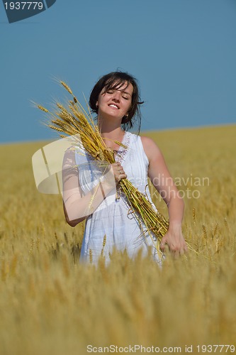 Image of young woman in wheat field at summer