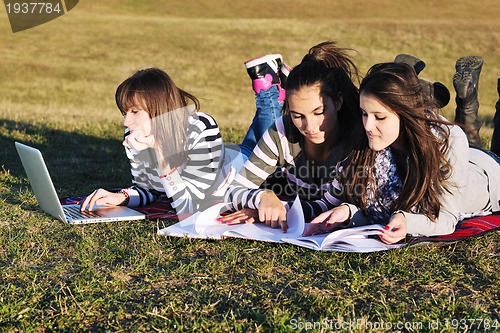 Image of group of teens working on laptop outdoor