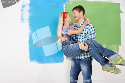 Image of happy couple paint wall at new home