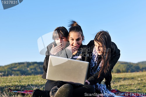Image of group of teens working on laptop outdoor