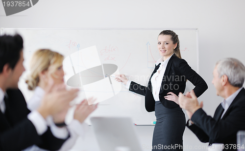 Image of business woman standing with her staff in background