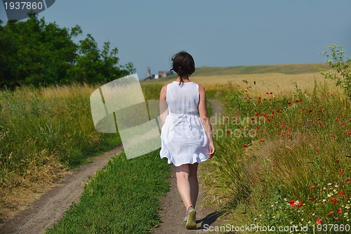 Image of young woman in wheat field at summer