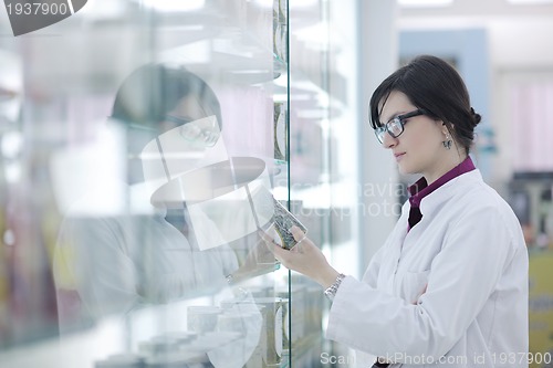 Image of pharmacist chemist woman standing in pharmacy drugstore