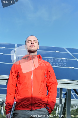 Image of engineer using laptop at solar panels plant field