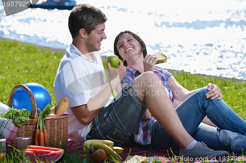 Image of happy young couple having a picnic outdoor