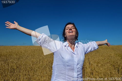Image of young woman in wheat field at summer