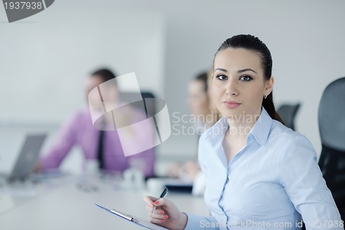 Image of business woman standing with her staff in background