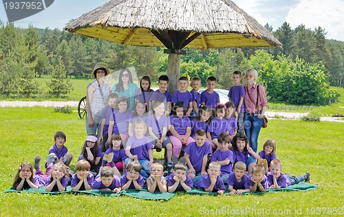 Image of happy kids group with teacher in nature