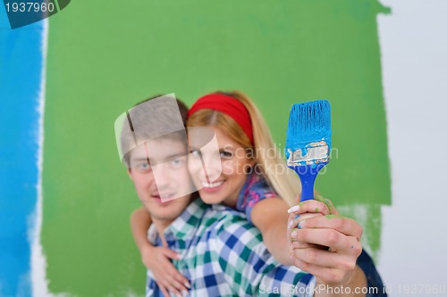 Image of happy couple paint wall at new home