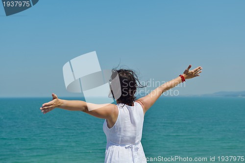Image of happy young woman with spreading arms to sky