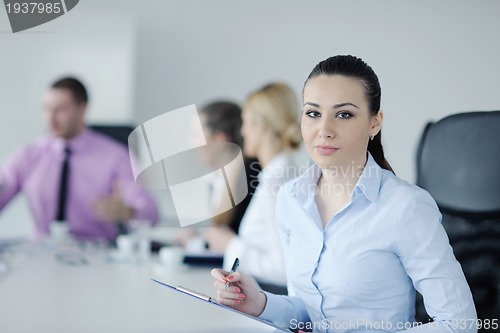 Image of business woman standing with her staff in background