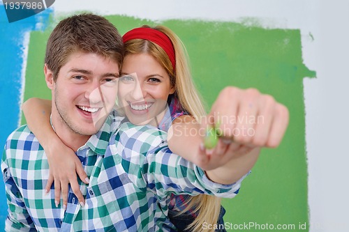 Image of happy couple paint wall at new home