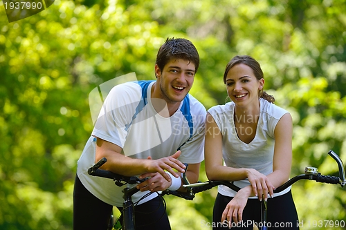 Image of Happy couple ridine bicycle outdoors