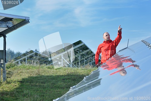 Image of engineer using laptop at solar panels plant field