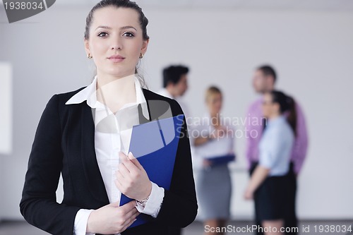 Image of business woman standing with her staff in background
