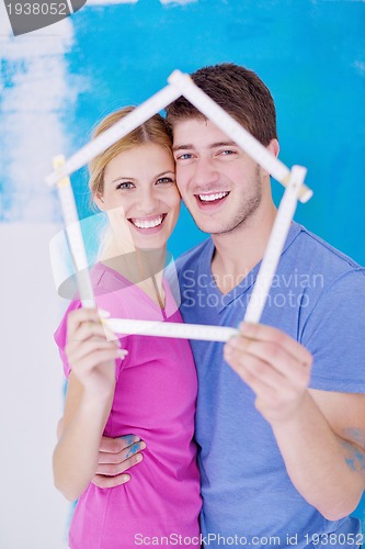 Image of happy couple paint wall at new home