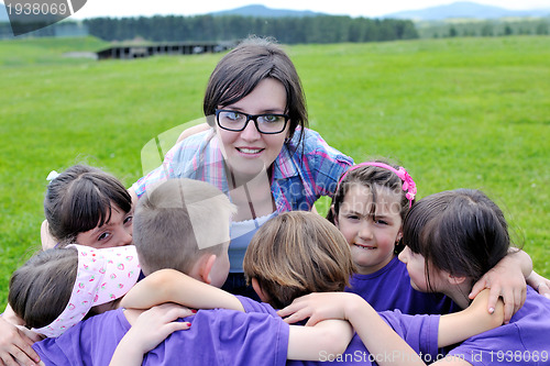 Image of happy kids group with teacher in nature