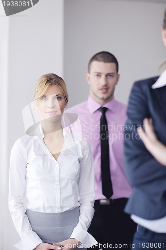 Image of business woman standing with her staff in background