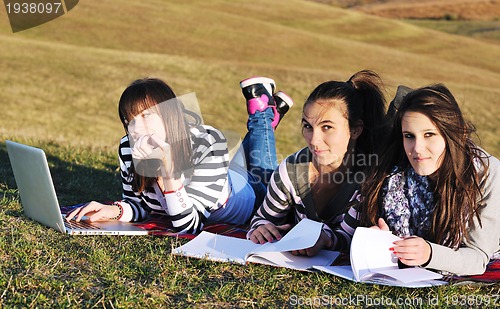 Image of group of teens working on laptop outdoor
