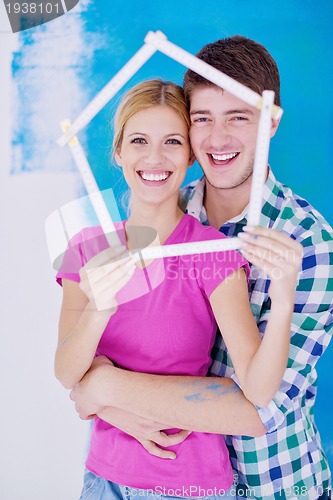 Image of happy couple paint wall at new home