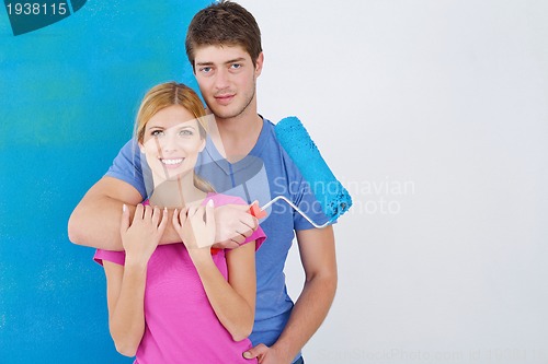 Image of happy couple paint wall at new home