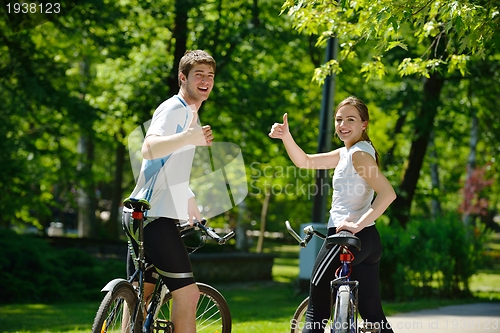 Image of Happy couple riding bicycle outdoors