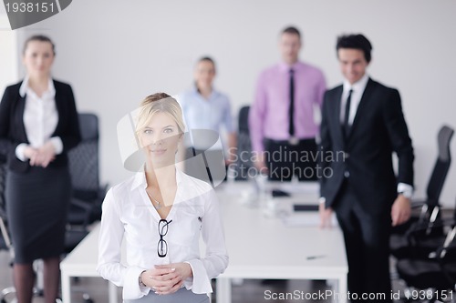 Image of business woman standing with her staff in background