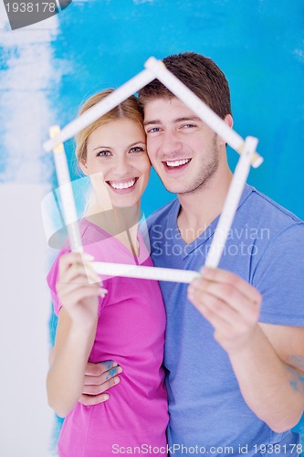 Image of happy couple paint wall at new home