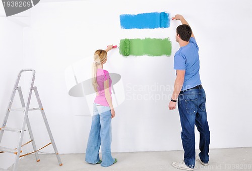 Image of happy couple paint wall at new home