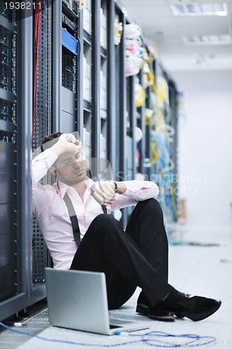 Image of businessman with laptop in network server room