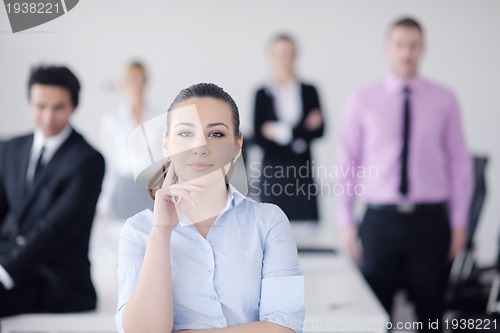 Image of business woman standing with her staff in background