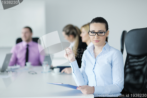 Image of business woman standing with her staff in background