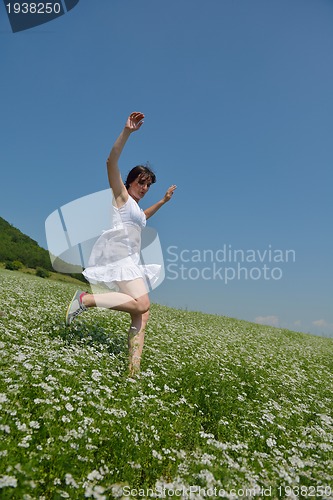 Image of Young happy woman in green field