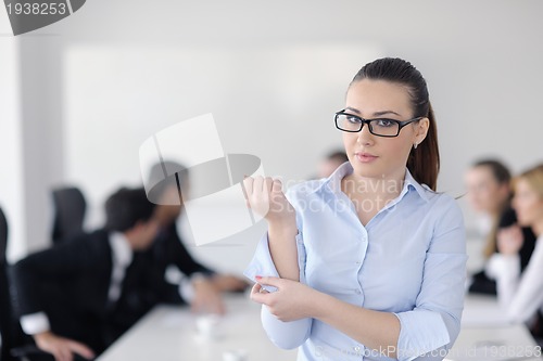Image of business woman standing with her staff in background
