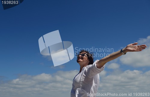 Image of happy young woman with spreading arms to sky