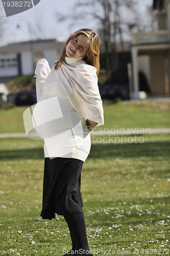 Image of happy young pregnant woman outdoor