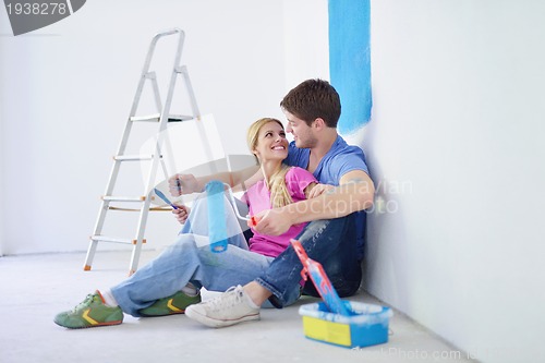 Image of happy young cople relaxing after painting in new home