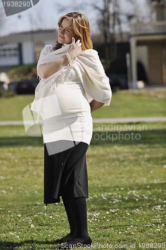 Image of happy young pregnant woman outdoor
