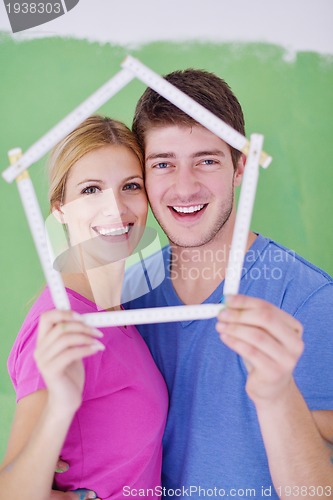 Image of happy couple paint wall at new home