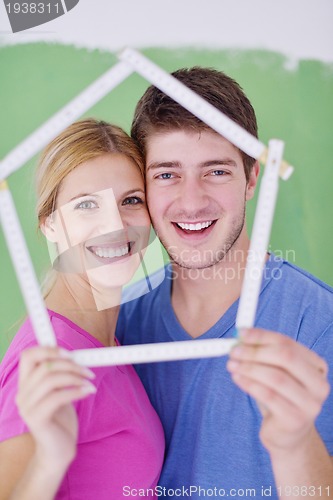 Image of happy couple paint wall at new home