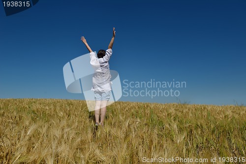 Image of young woman in wheat field at summer