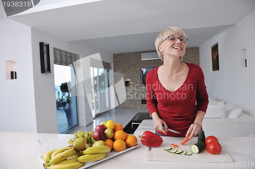 Image of happy  beautiful blonde  woman prepare food in  the kitchen