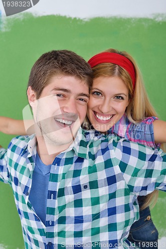 Image of happy couple paint wall at new home