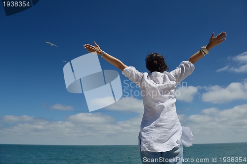 Image of young woman with spreading arms to sky