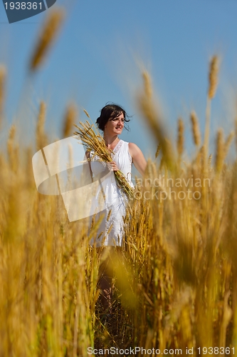Image of young woman in wheat field at summer