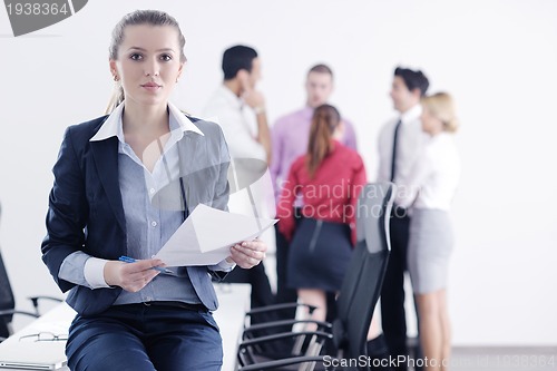 Image of business woman standing with her staff in background